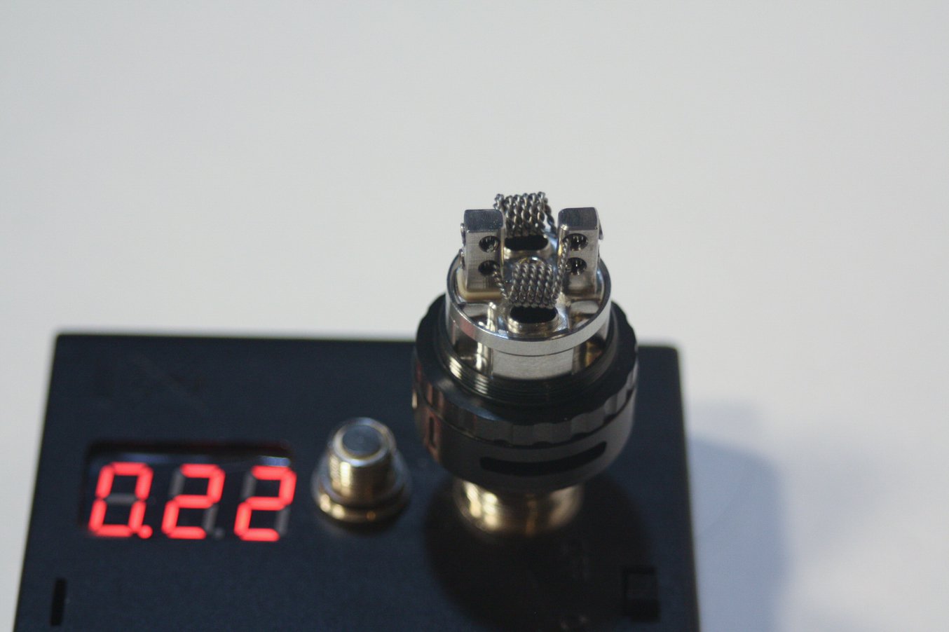 photo of a vape deck with a twisted wire kanthal coil build on a ohm meter