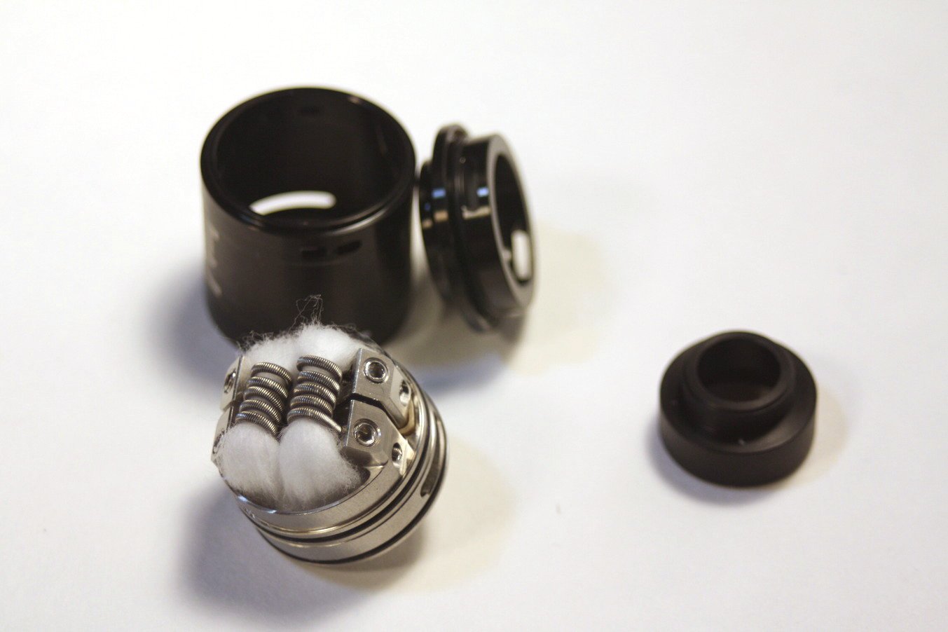 the Augvape BTFC RDA disassembled showing a dual coil build with top and bottom airflow slots for huge flavor and clouds